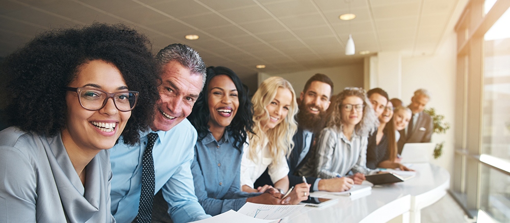 Cheerful multiracial colleagues looking at camera in office