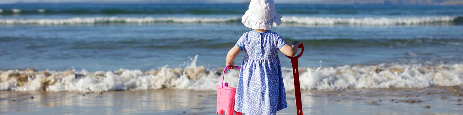 baby girl playing at summer beach